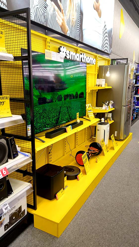 Yellow retail display fixtures with televisions and household appliances
