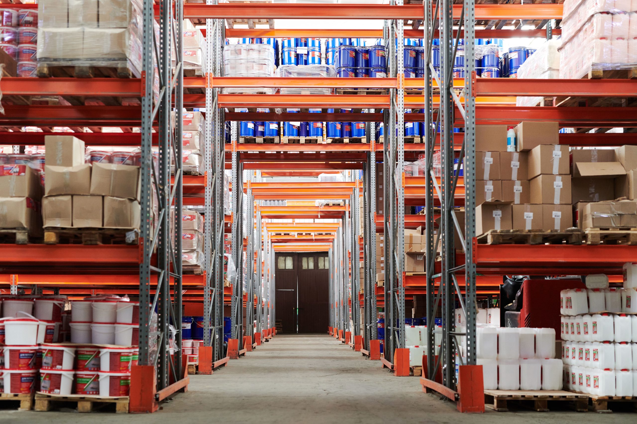 Warehouse aisle with pallet racking holding boxed stock and containers