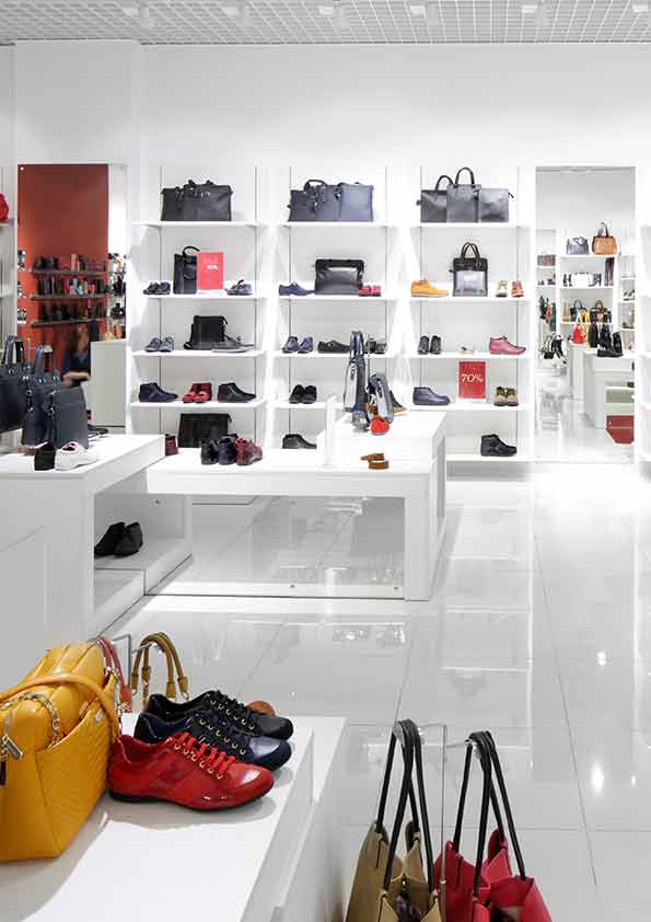White display tables and wall shelves presenting shoes and bags