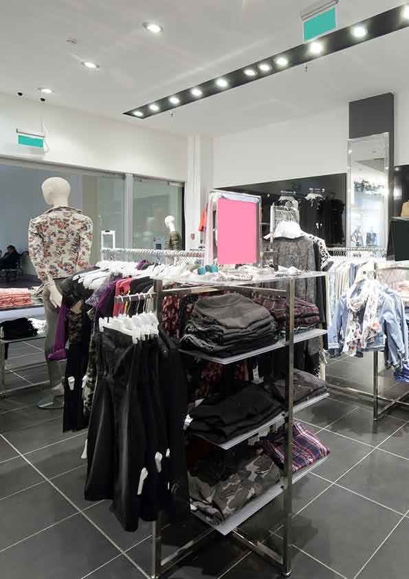 Freestanding clothing fixture with shelves and hanging rails